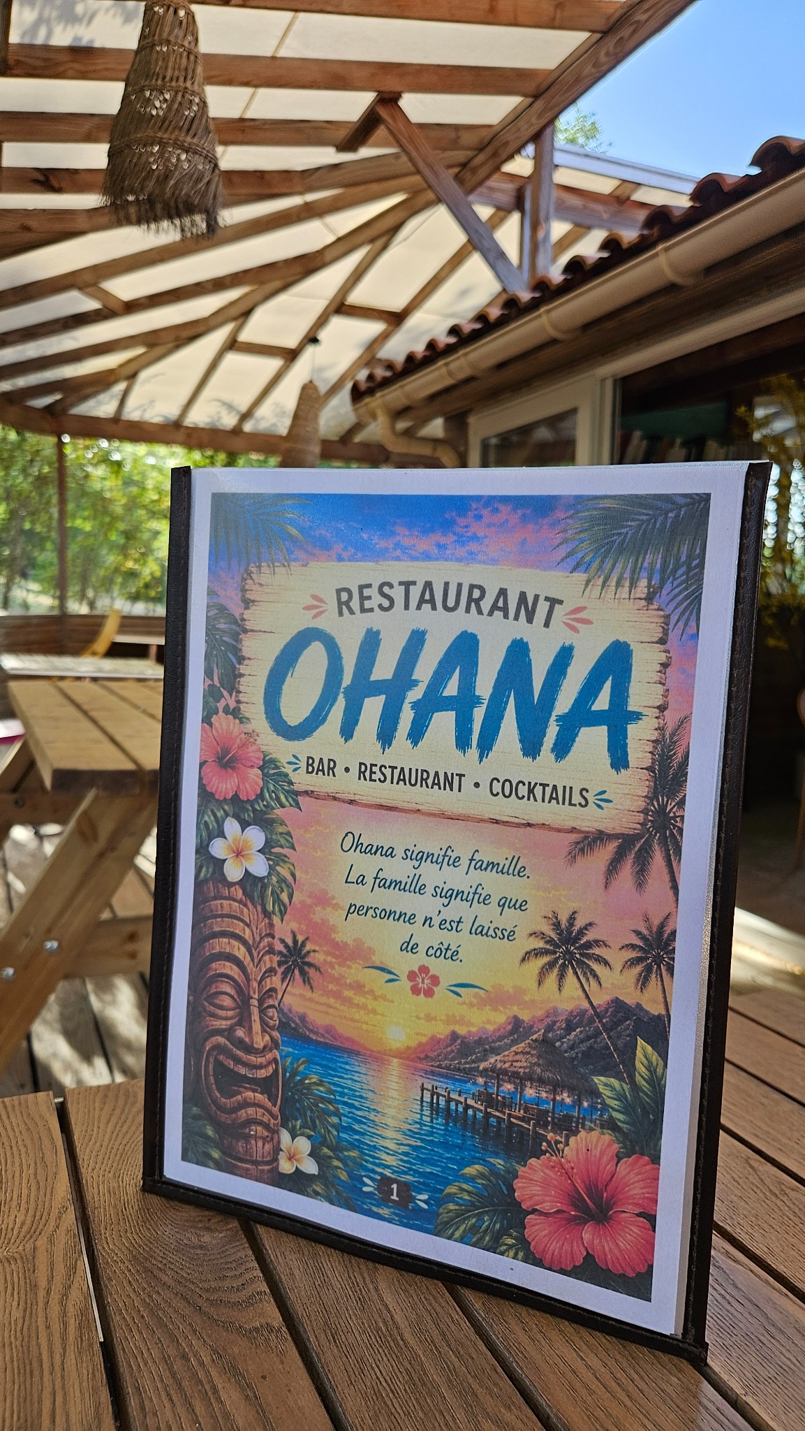 La couverture de la carte du restaurant Ohana posée sur une table de la terrasse couverte