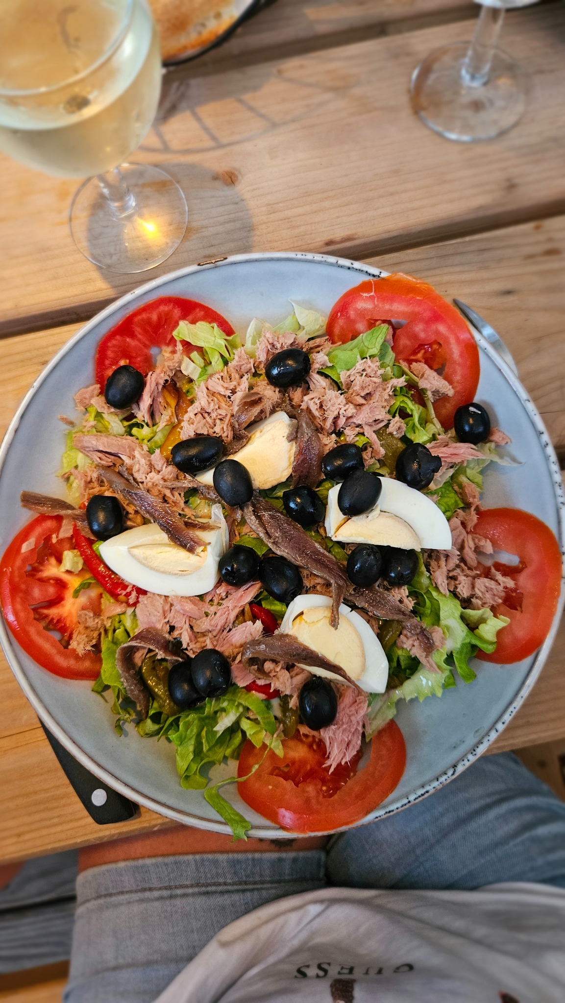 Salade composée avec tomates, œufs, olives et poisson, servie au restaurant du Camping Ohana