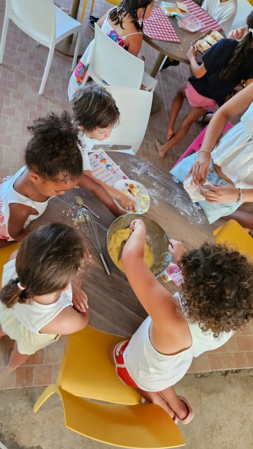 Les enfants préparent une recette ensemble autour d’une table au Camping Ohana