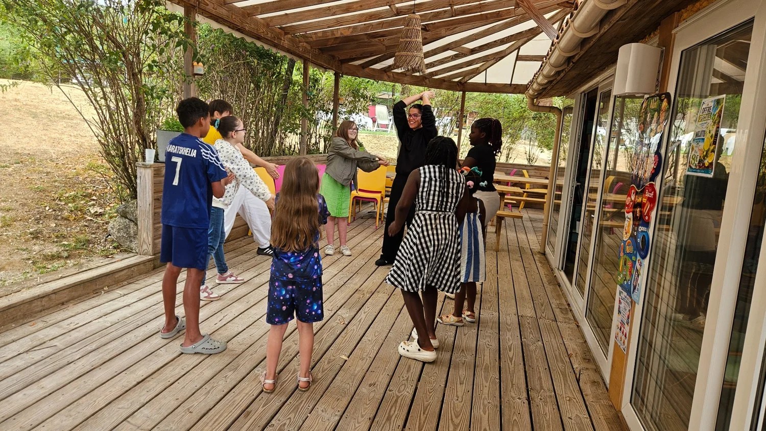 Un groupe d’enfants participe à un jeu sur la terrasse du Camping Ohana