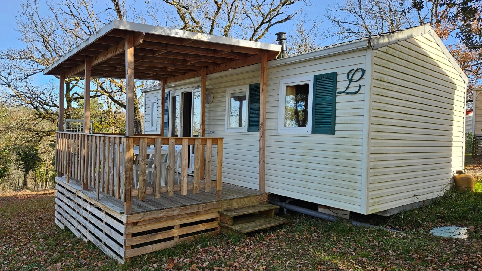 Mobil-home du Camping Ohana avec terrasse couverte et volets verts