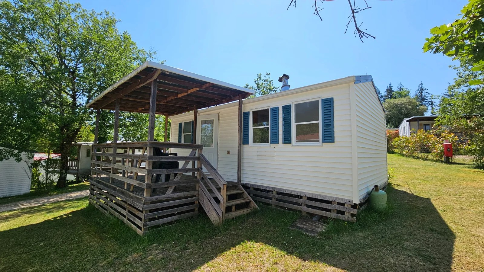 Vue extérieure d’un mobil-home du Camping Ohana et de sa terrasse couverte