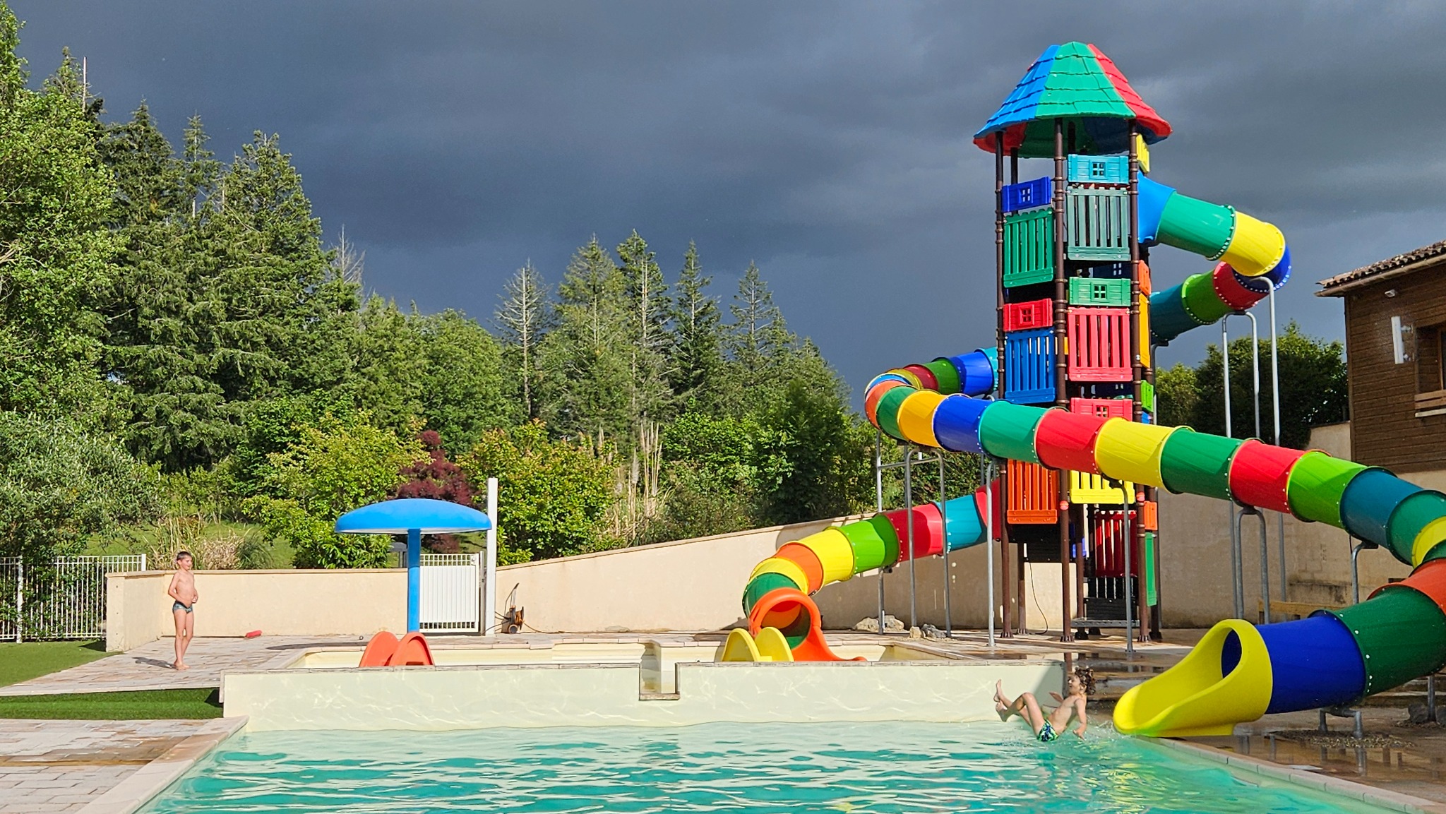 Des vacanciers profitent des toboggans et de la piscine du Camping Ohana