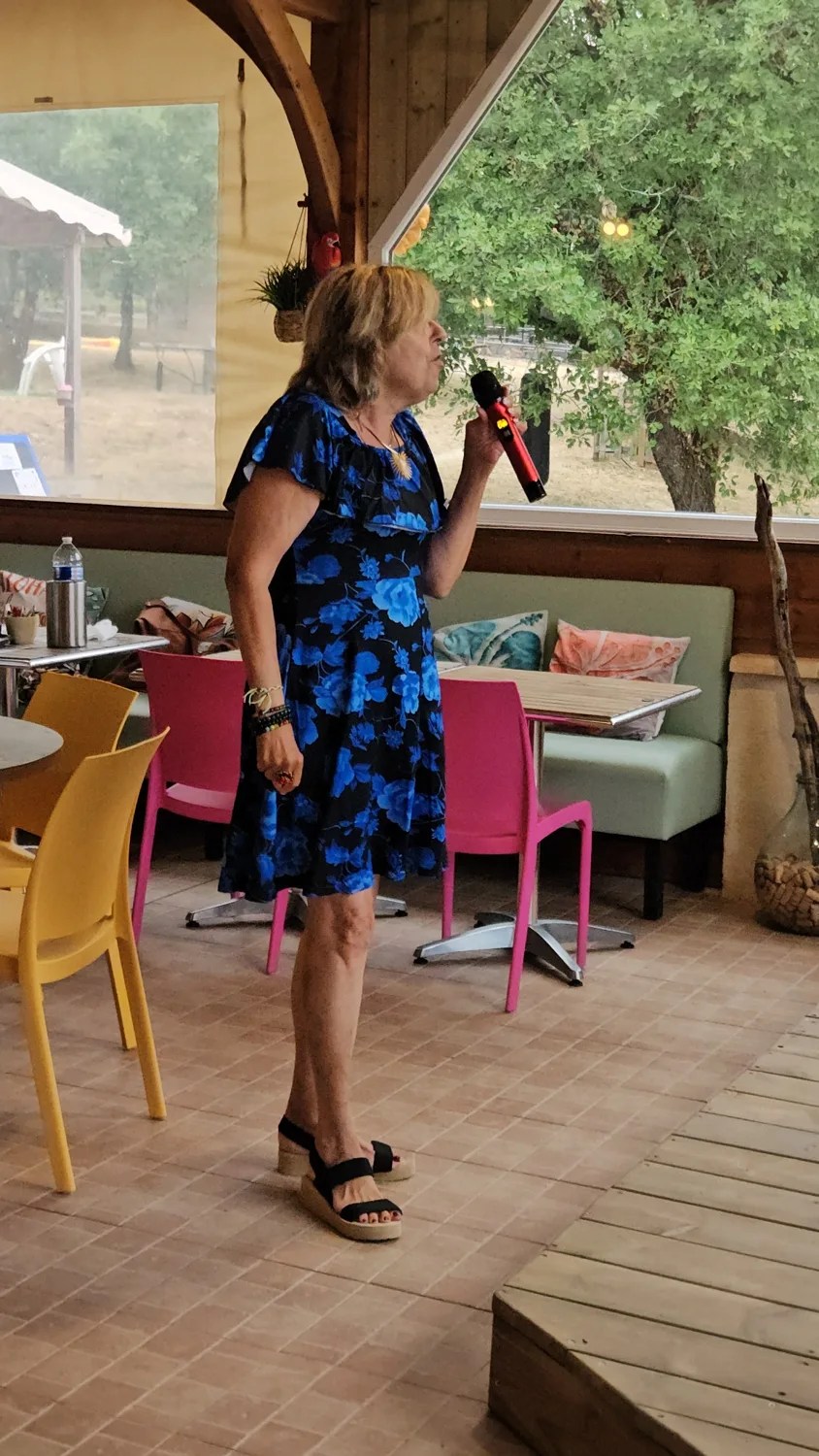 Une participante chante au micro pendant un karaoké du Camping Ohana