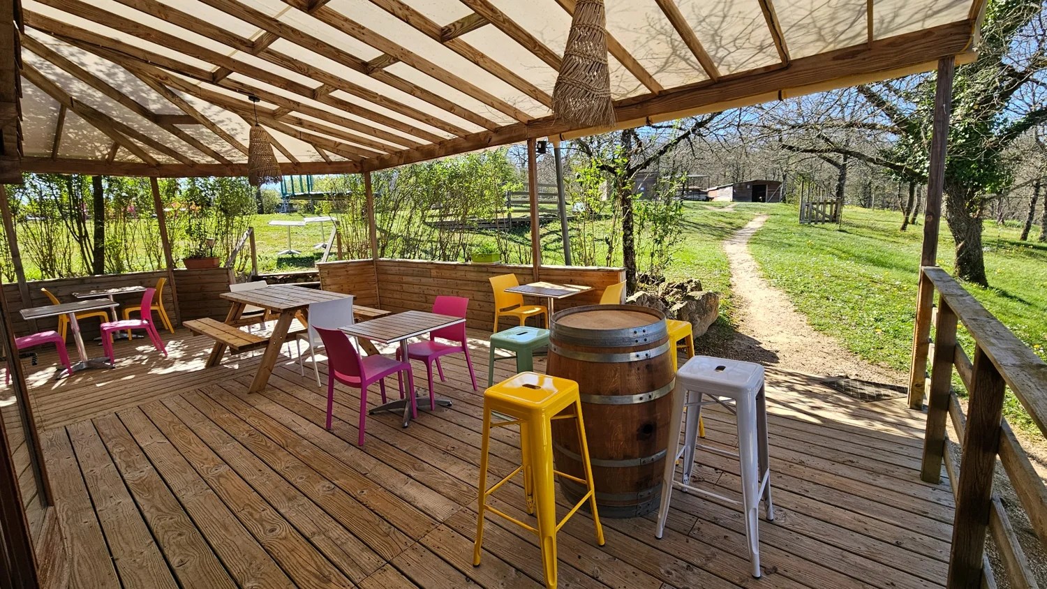 La terrasse couverte du Camping Ohana ouverte sur les espaces arborés